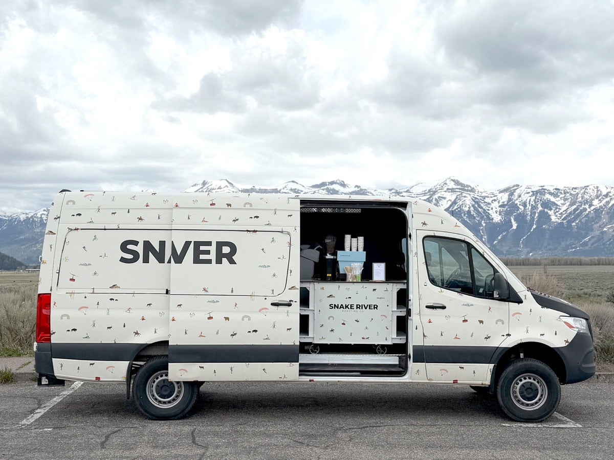 The Van parked with its serving door open, Tetons behind
