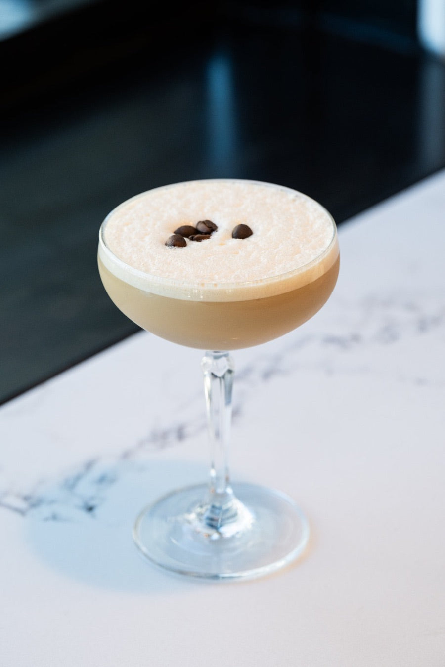 An espresso martini topped with coffee beans