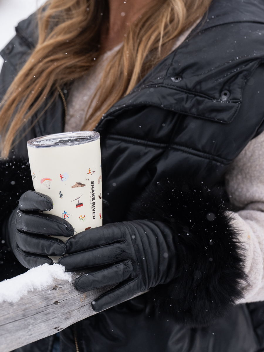Gloved hands cradling a patterned Snake River cup in the cold