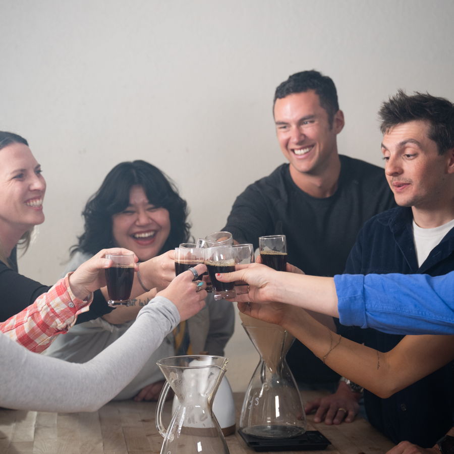 Friends raising coffee mugs together