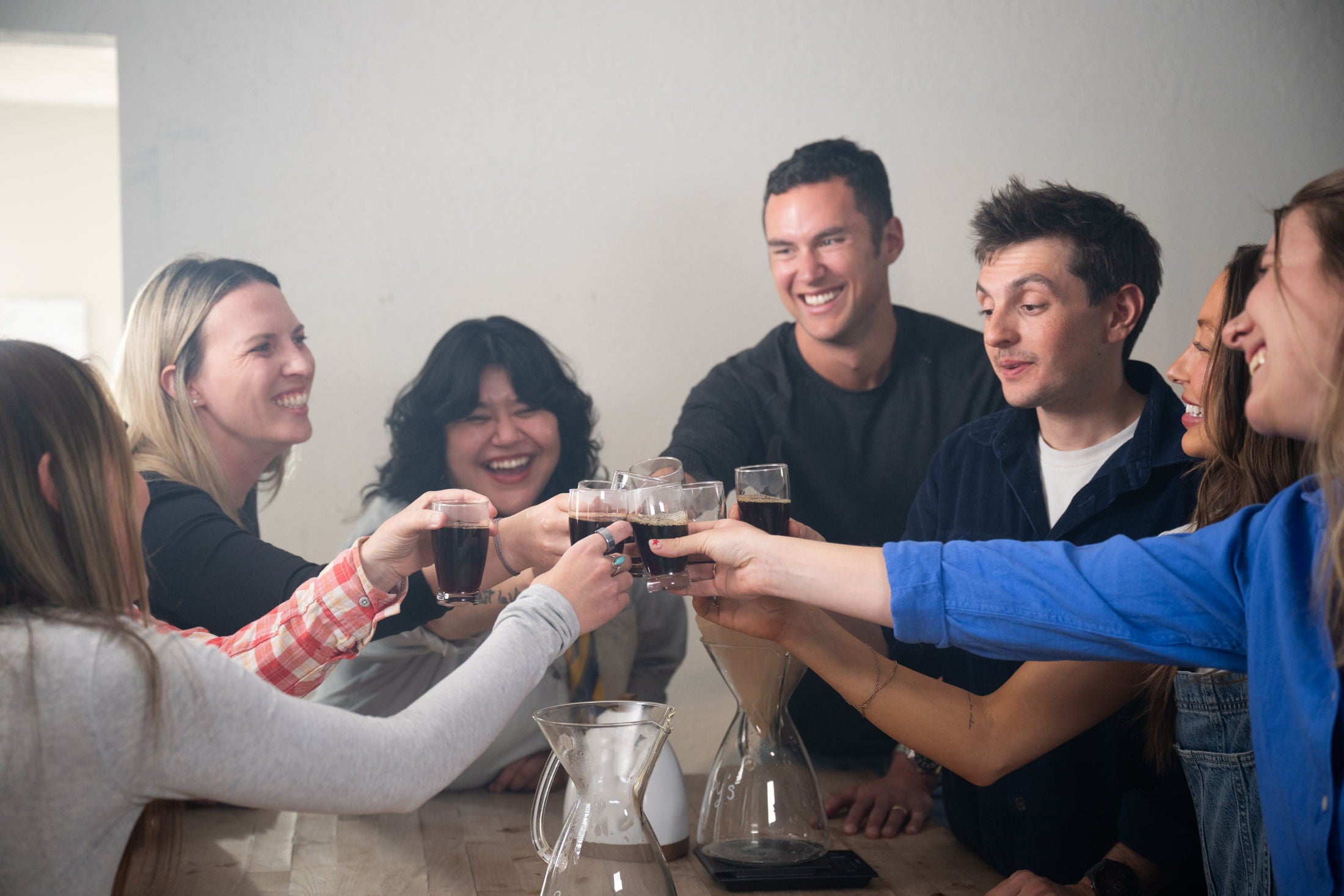 Friends raising coffee mugs together