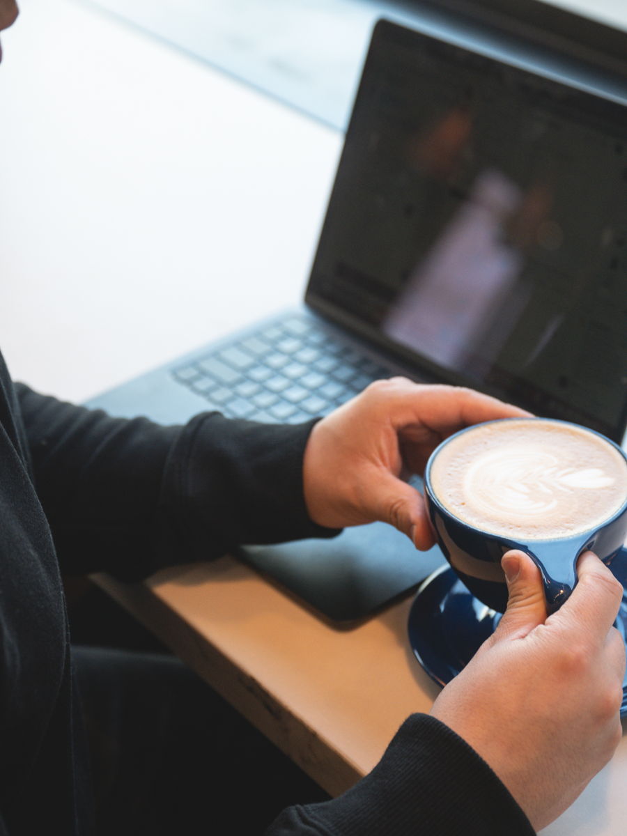 A latte beside a laptop on a work morning