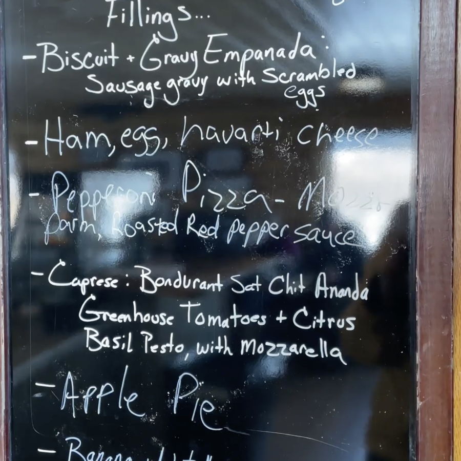 The specials chalkboard listing the day&rsquo;s empanada fillings