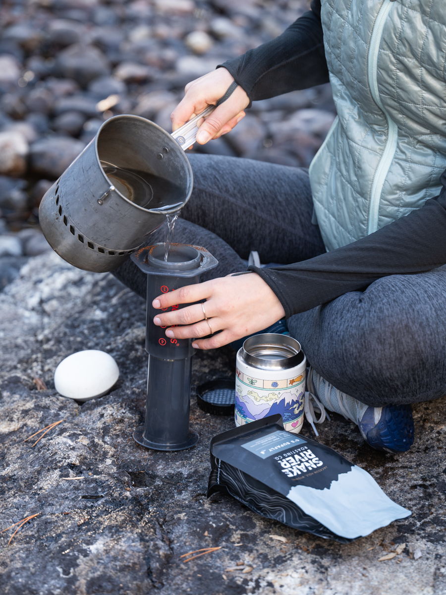Brewing coffee on a flat rock in the backcountry, scale and kettle set out